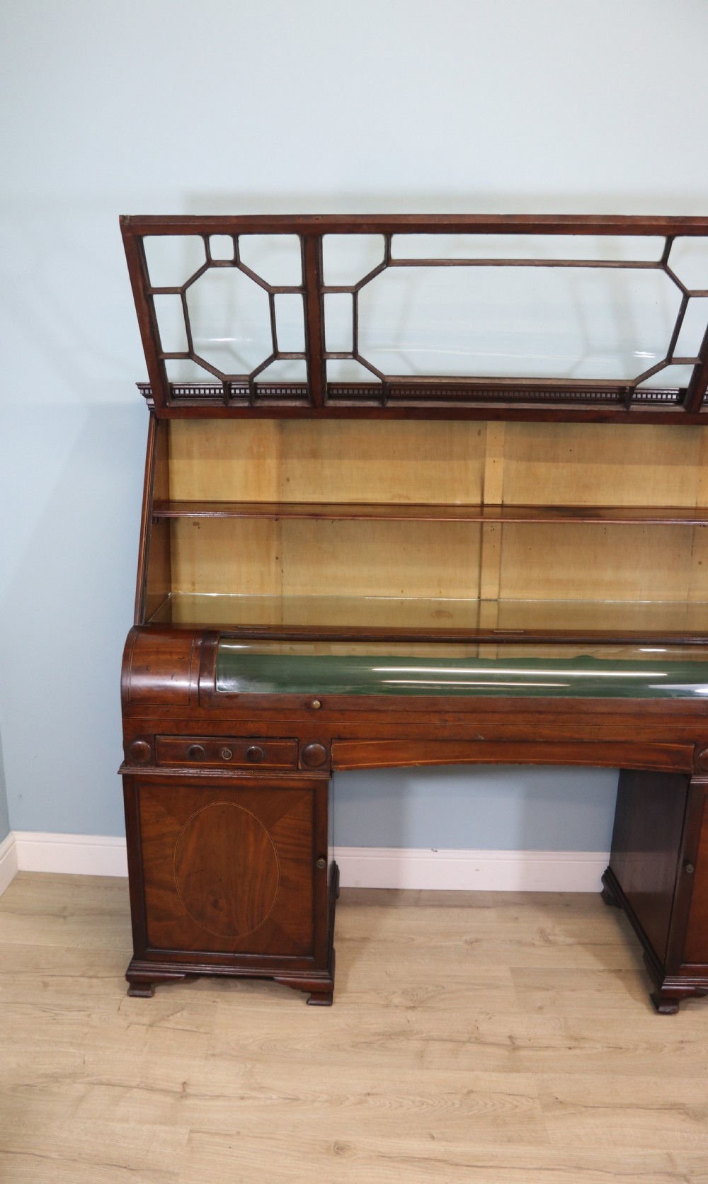 An early nineteenth-century mahogany twin pedestal display cabinet featuring glazed upper doors with geometric glazing bars, a central curved glass display section, and inlaid pedestal cupboards below. View V