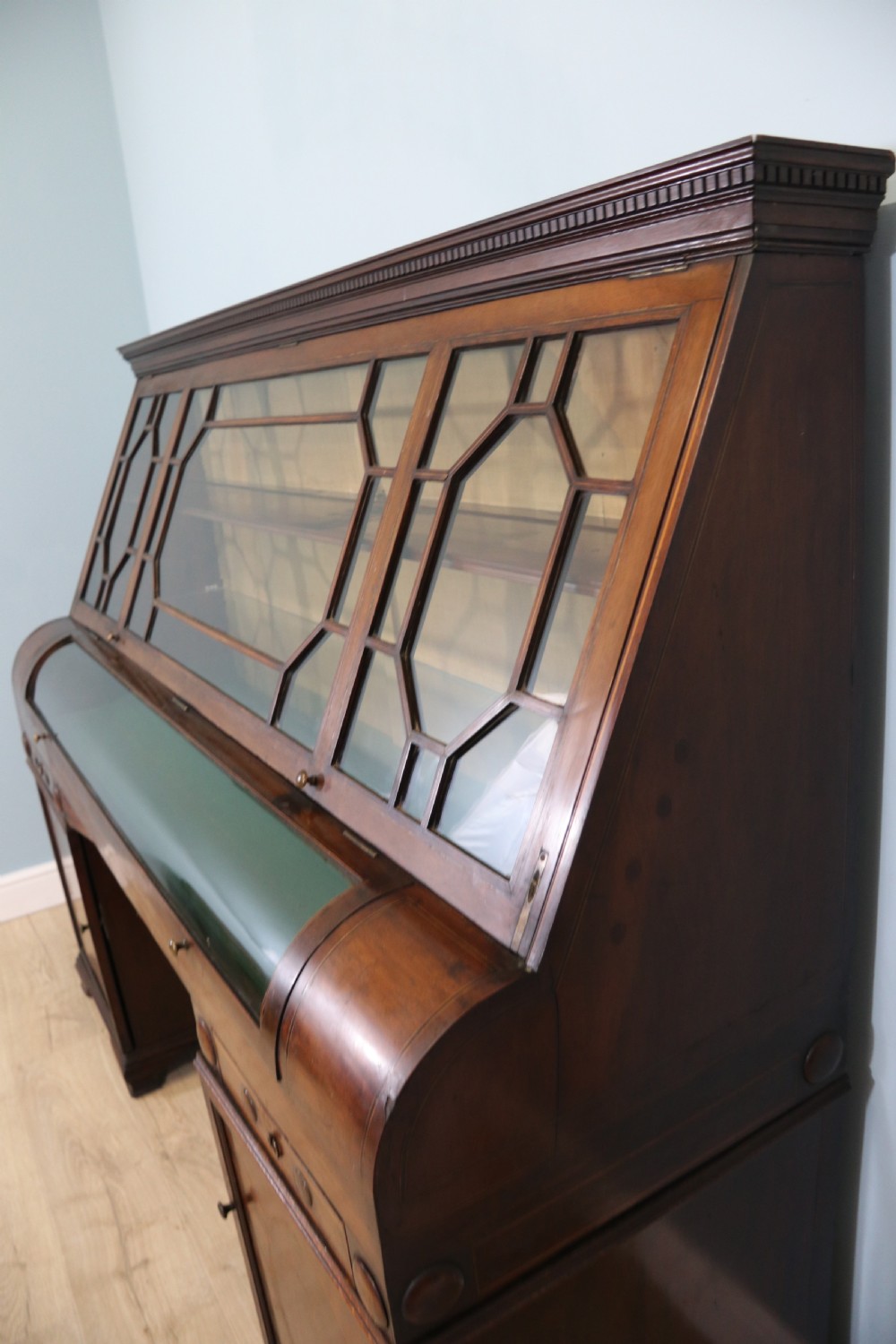 An early nineteenth-century mahogany twin pedestal display cabinet featuring glazed upper doors with geometric glazing bars, a central curved glass display section, and inlaid pedestal cupboards below. View IX