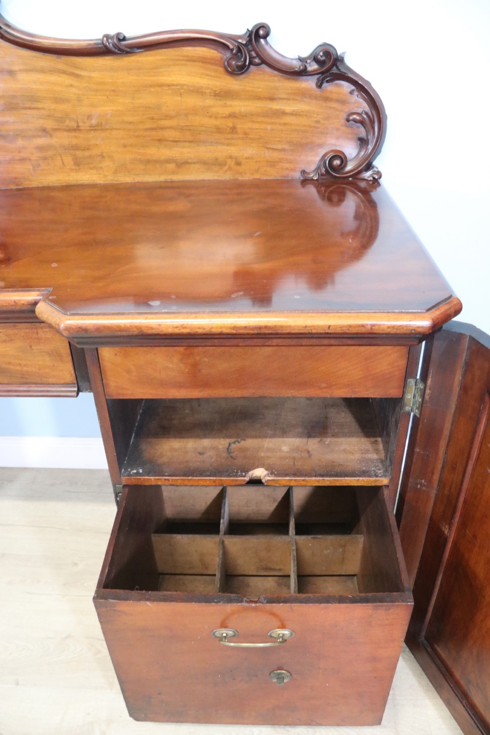 A Victorian mahogany twin pedestal sideboard featuring a central frieze drawer, carved splashback, and flame mahogany cupboard doors on plinth bases. View XII