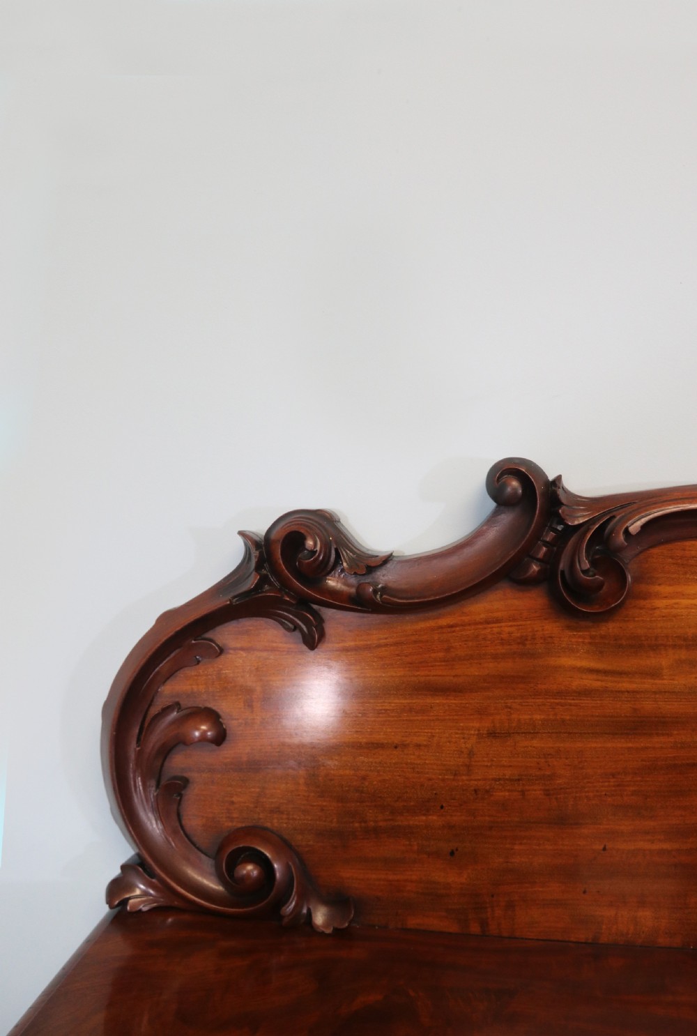 A Victorian mahogany twin pedestal sideboard featuring a central frieze drawer, carved splashback, and flame mahogany cupboard doors on plinth bases. View XIX