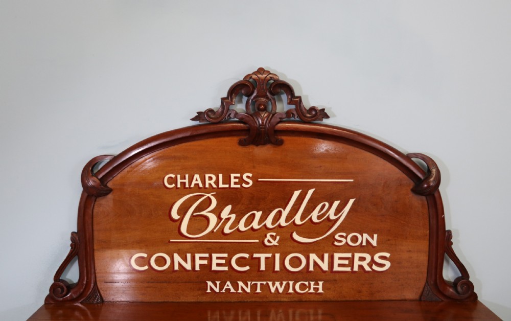 A Victorian mahogany chiffonier featuring hand-painted cream and red commercial typography across the upper cresting back and lower cupboard doors. View V