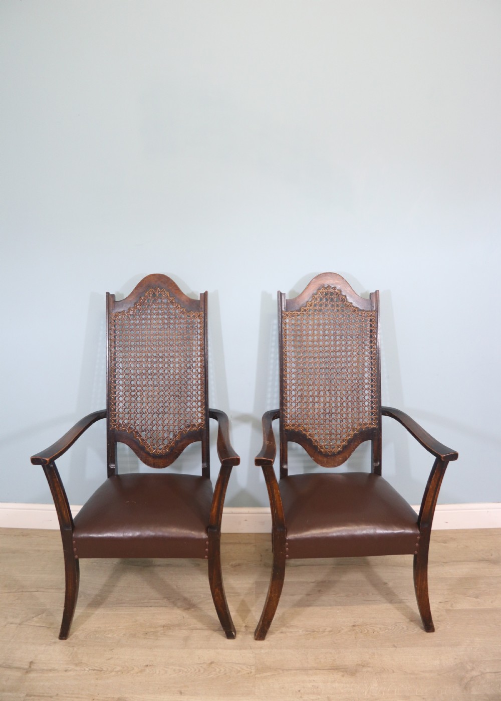 A lovely pair of early 20th century industrial looking cane shield back armchairs