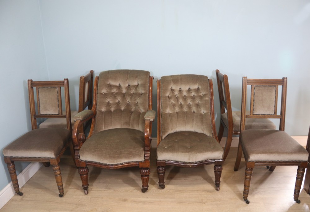 A six-piece late 19th-century chair suite featuring two button-back upholstered armchairs and four matching side chairs upholstered in taupe velvet with turned wooden front legs on castors. View II