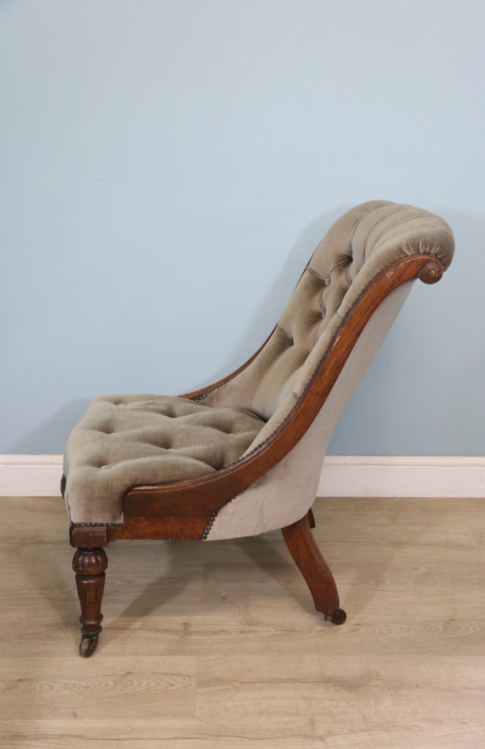 A six-piece late 19th-century chair suite featuring two button-back upholstered armchairs and four matching side chairs upholstered in taupe velvet with turned wooden front legs on castors. View XXVI