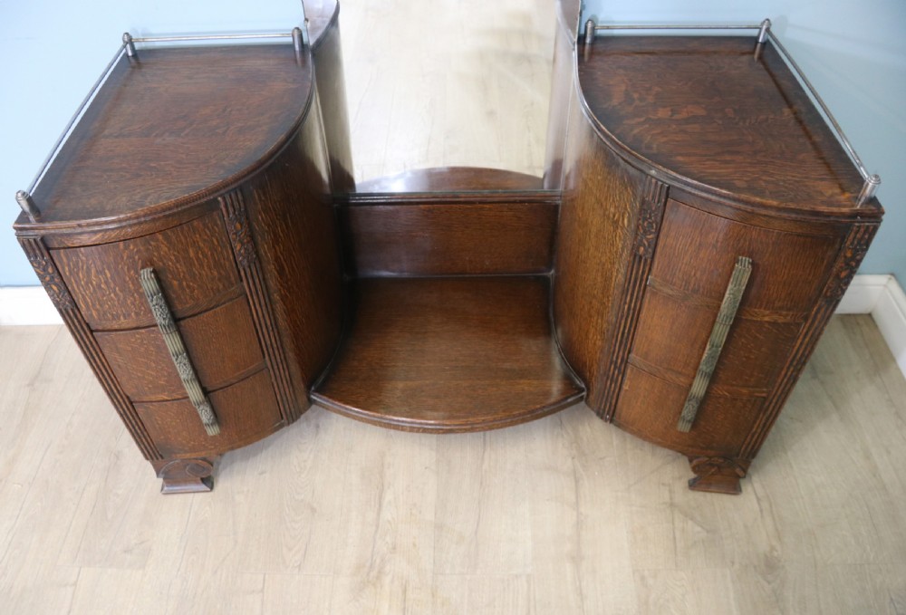 An Art Deco dark oak twin pedestal dressing chest featuring a central full-length arched mirror flanked by two curved three-drawer pedestals with metal gallery rails. View IV