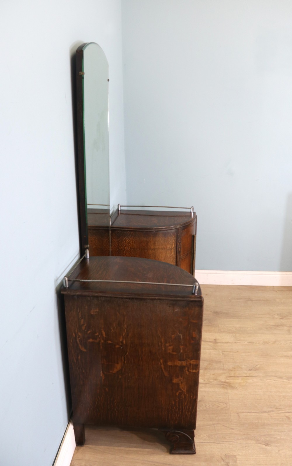 An Art Deco dark oak twin pedestal dressing chest featuring a central full-length arched mirror flanked by two curved three-drawer pedestals with metal gallery rails. View VII