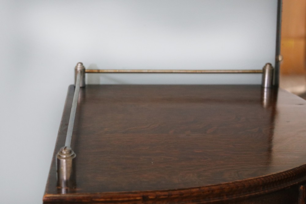 An Art Deco dark oak twin pedestal dressing chest featuring a central full-length arched mirror flanked by two curved three-drawer pedestals with metal gallery rails. View XV