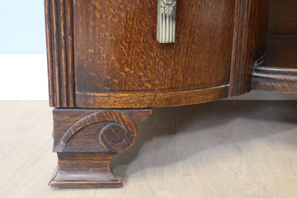 An Art Deco dark oak twin pedestal dressing chest featuring a central full-length arched mirror flanked by two curved three-drawer pedestals with metal gallery rails. View XVI