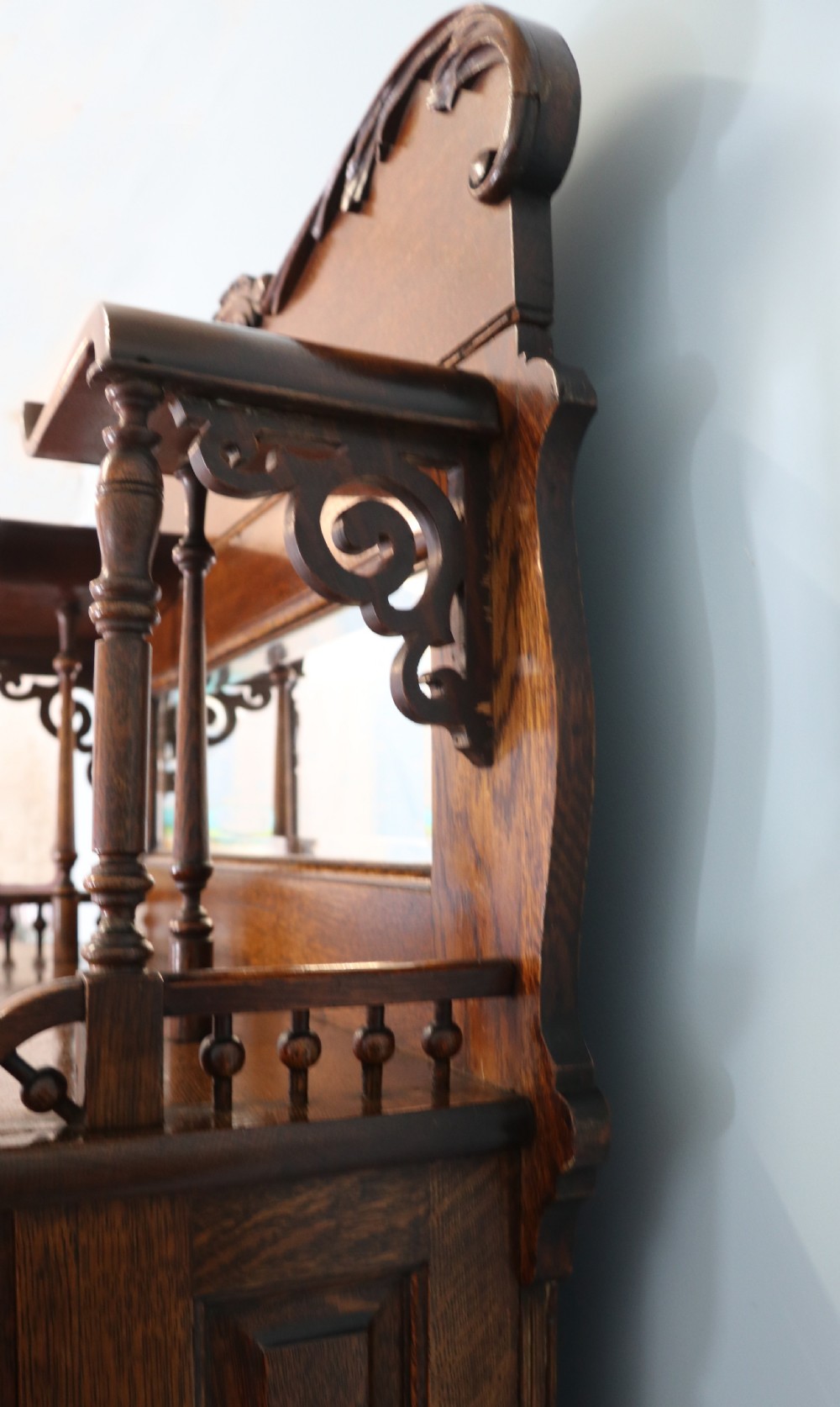 A late nineteenth-century oak combination dentist cabinet featuring a mirrored gallery top, carved foliate door, tambour section, and multiple small drawers. View XVI