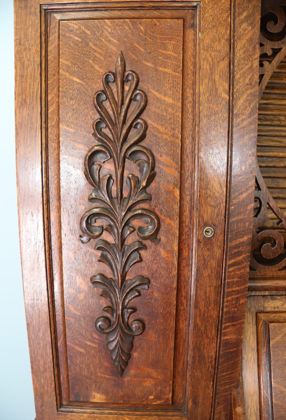 A late nineteenth-century oak combination dentist cabinet featuring a mirrored gallery top, carved foliate door, tambour section, and multiple small drawers. View XXVIII