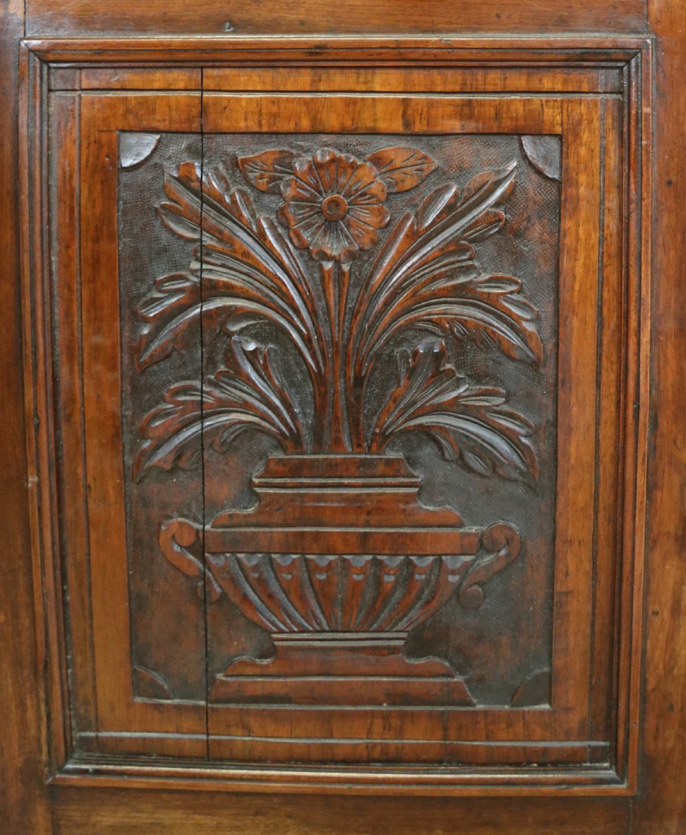 A two-tier dark walnut display cabinet featuring glazed upper doors decorated with vintage Cadburys advertising lettering above lower carved wooden cupboard doors. View XIX