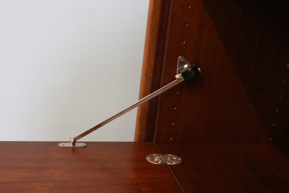 A pair of mid-century teak display cabinets featuring upper sliding glass doors, internal shelving, lower wooden cupboards, drawers, and brass fittings. View VIII