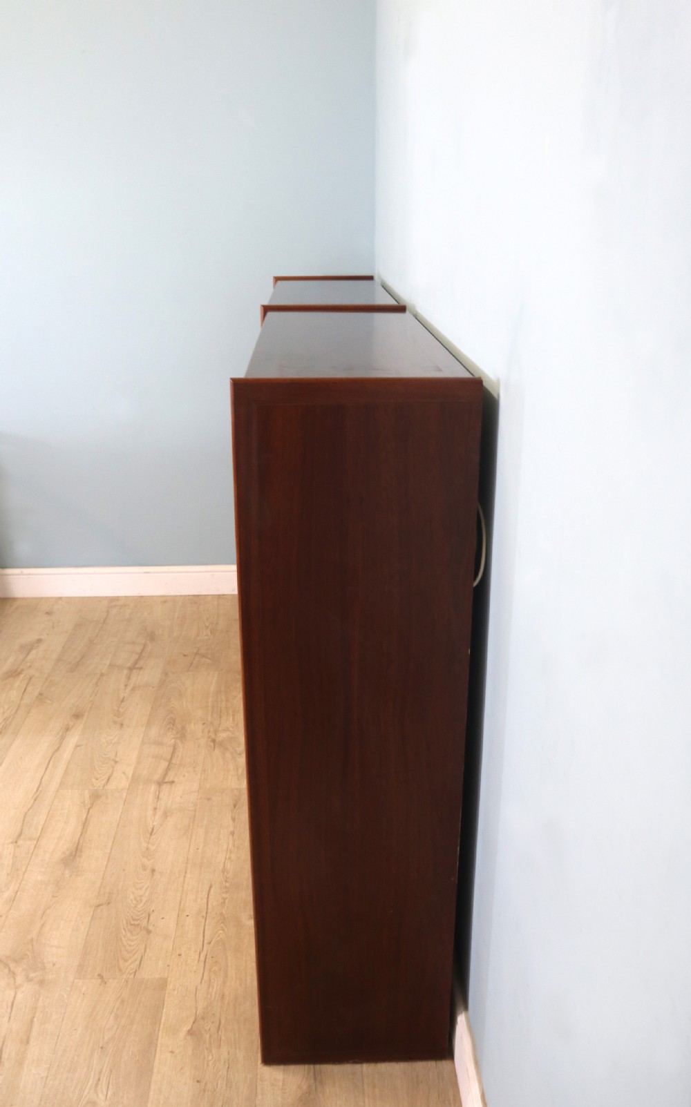 A pair of mid-century teak display cabinets featuring upper sliding glass doors, internal shelving, lower wooden cupboards, drawers, and brass fittings. View XIX