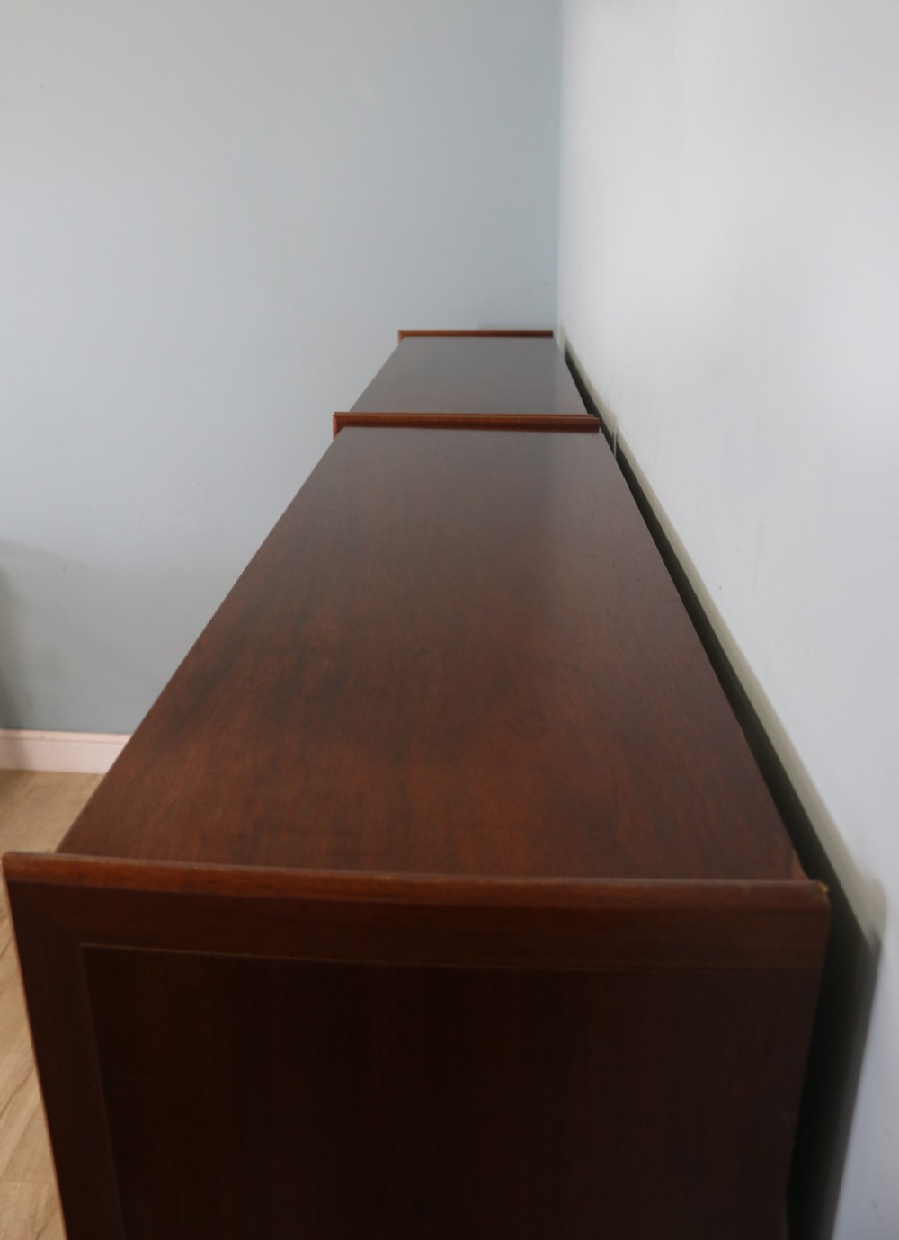 A pair of mid-century teak display cabinets featuring upper sliding glass doors, internal shelving, lower wooden cupboards, drawers, and brass fittings. View XX