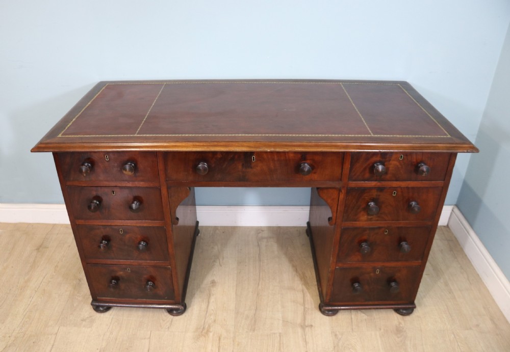 Lovely flame mahogany veneered twin pedestal desk has a tooled leather writing surface 