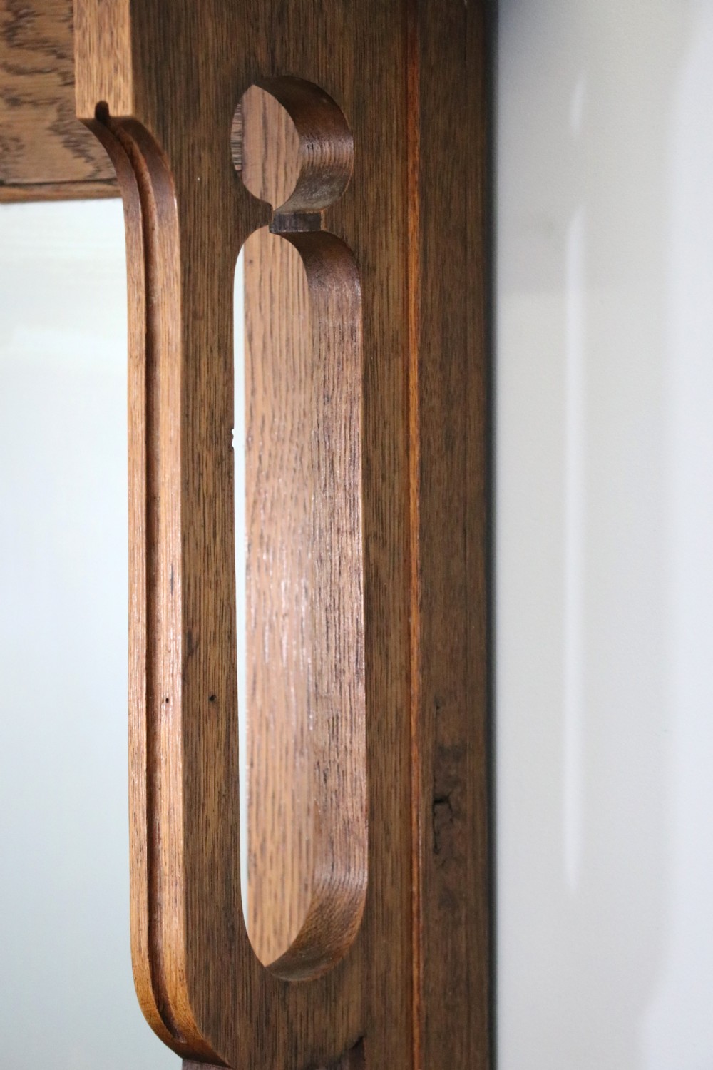 A late Victorian oak sideboard featuring a mirrored upper shelf, two drawers, and two carved panel cupboard doors. View VIII