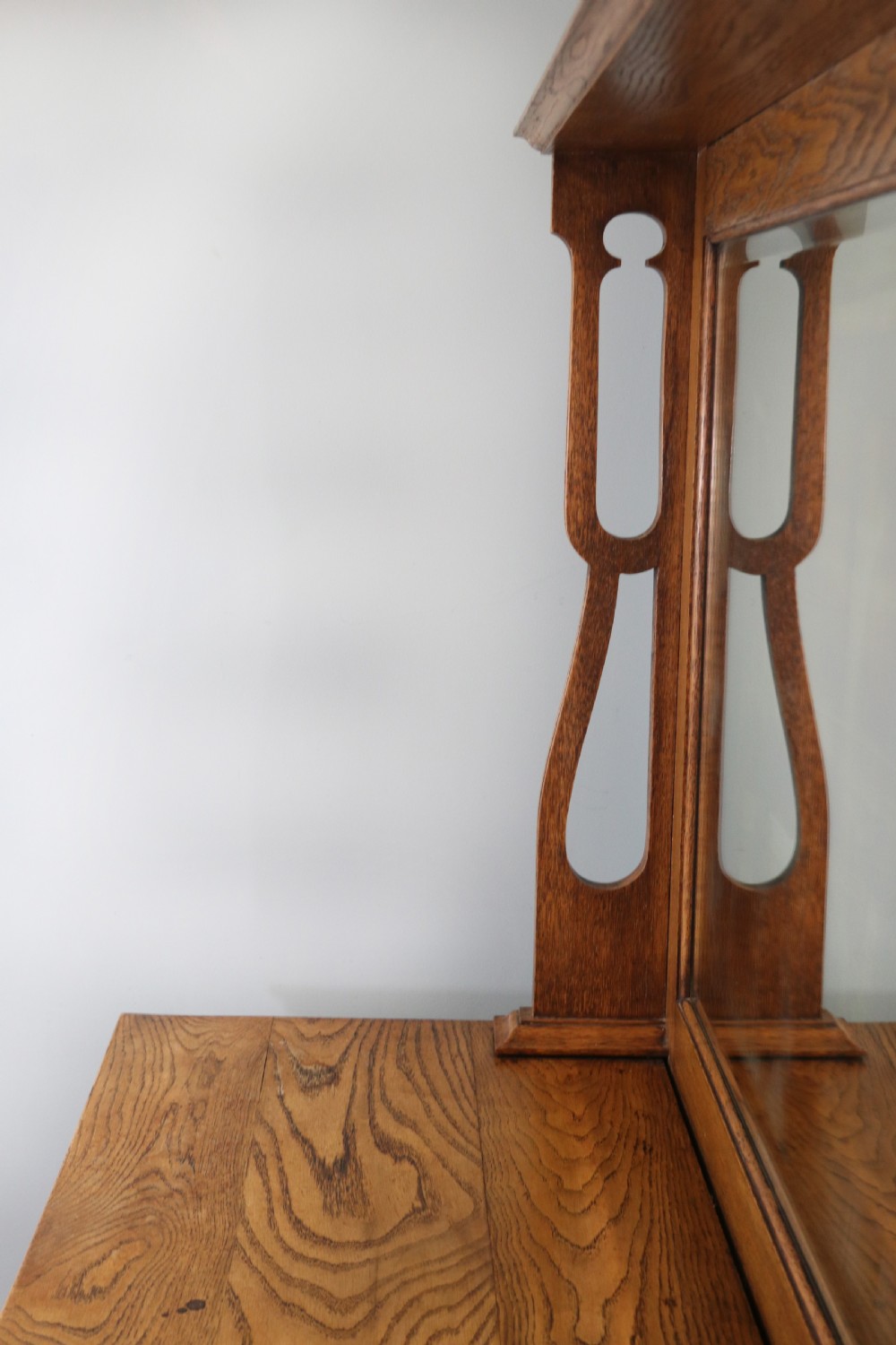 A late Victorian oak sideboard featuring a mirrored upper shelf, two drawers, and two carved panel cupboard doors. View IX