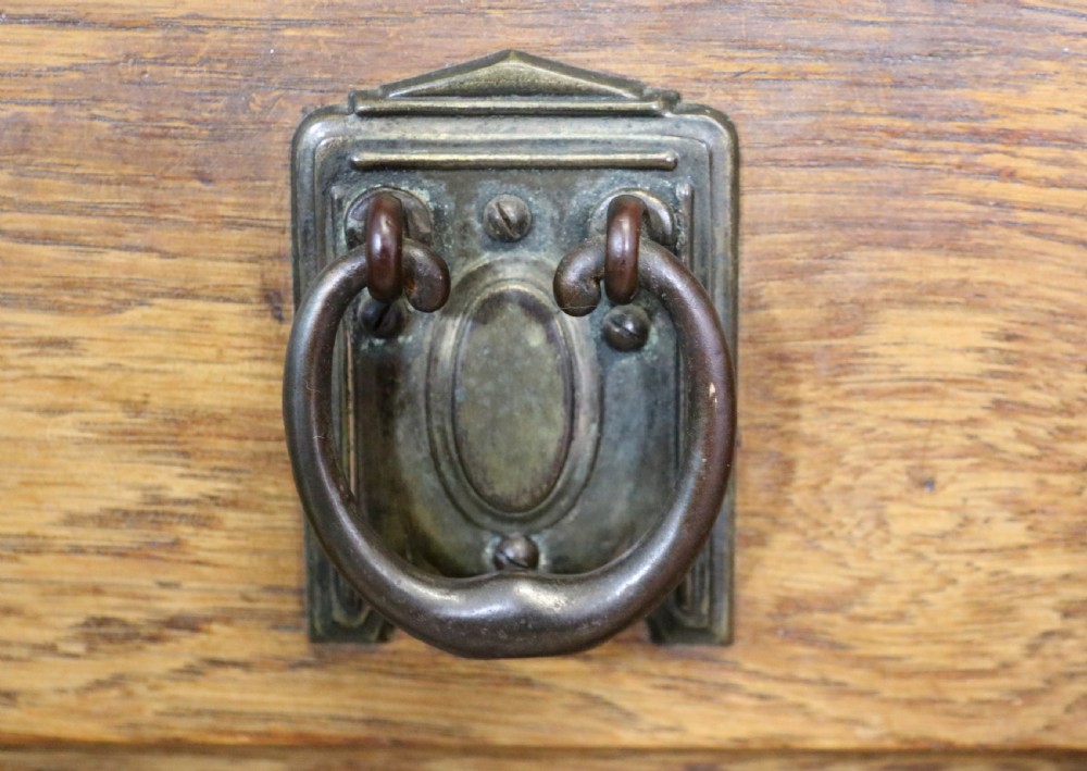 A late Victorian oak sideboard featuring a mirrored upper shelf, two drawers, and two carved panel cupboard doors. View XII