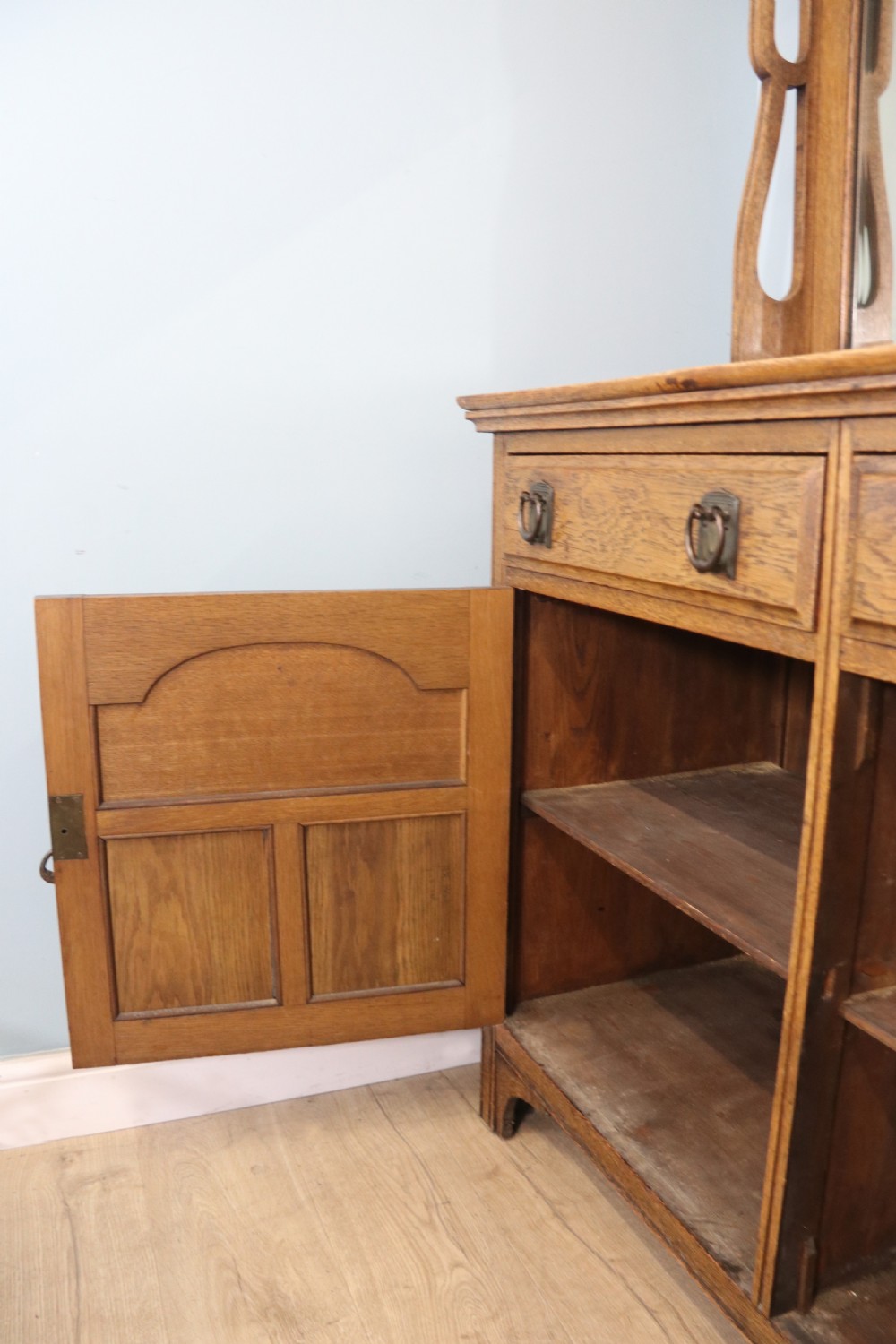 A late Victorian oak sideboard featuring a mirrored upper shelf, two drawers, and two carved panel cupboard doors. View XIV