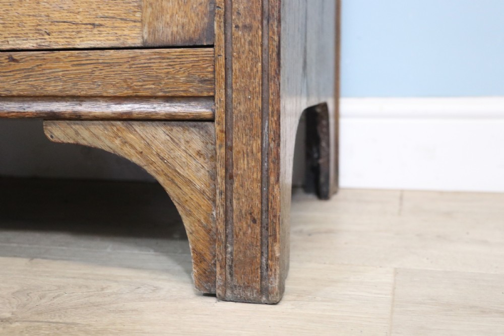 A late Victorian oak sideboard featuring a mirrored upper shelf, two drawers, and two carved panel cupboard doors. View XIX