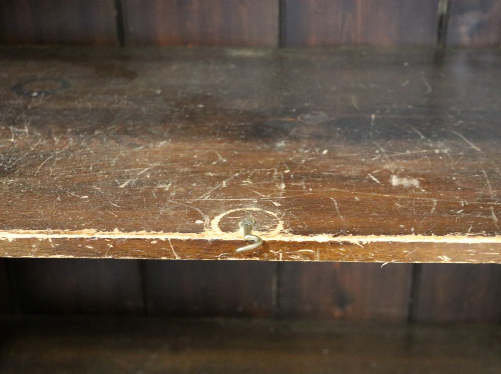 A late 19th-century warm brown walnut glazed bookcase cabinet featuring gilded sign-written trade lettering across the glass doors and lower timber panels. View XII