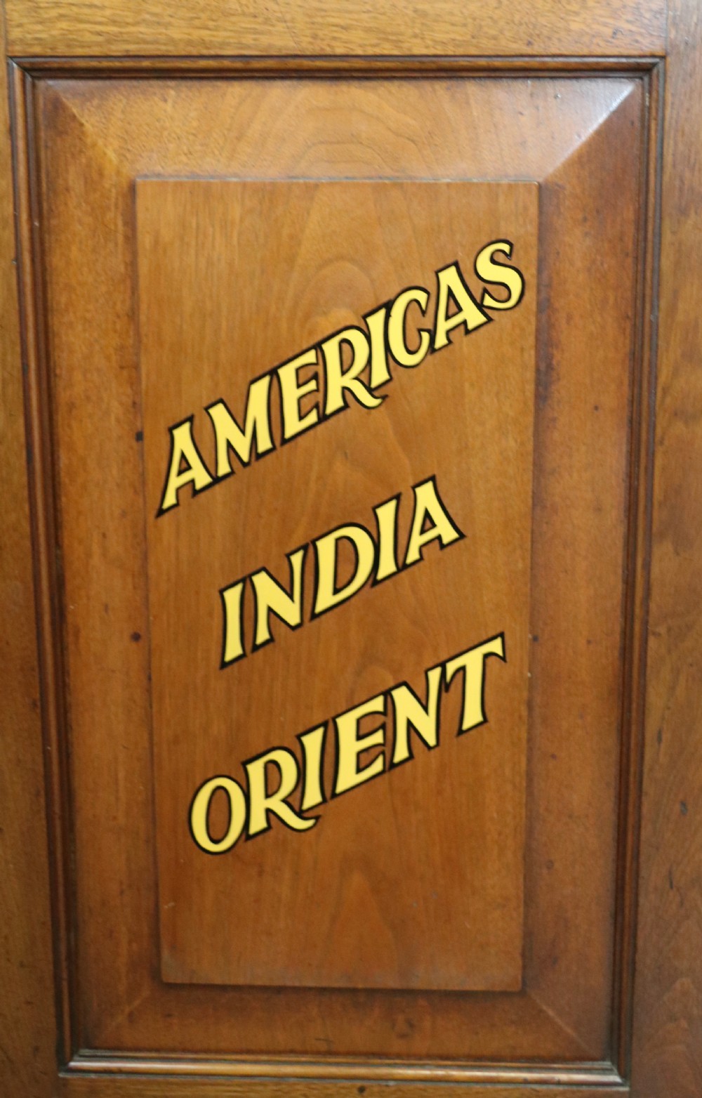 A late 19th-century warm brown walnut glazed bookcase cabinet featuring gilded sign-written trade lettering across the glass doors and lower timber panels. View XVIII