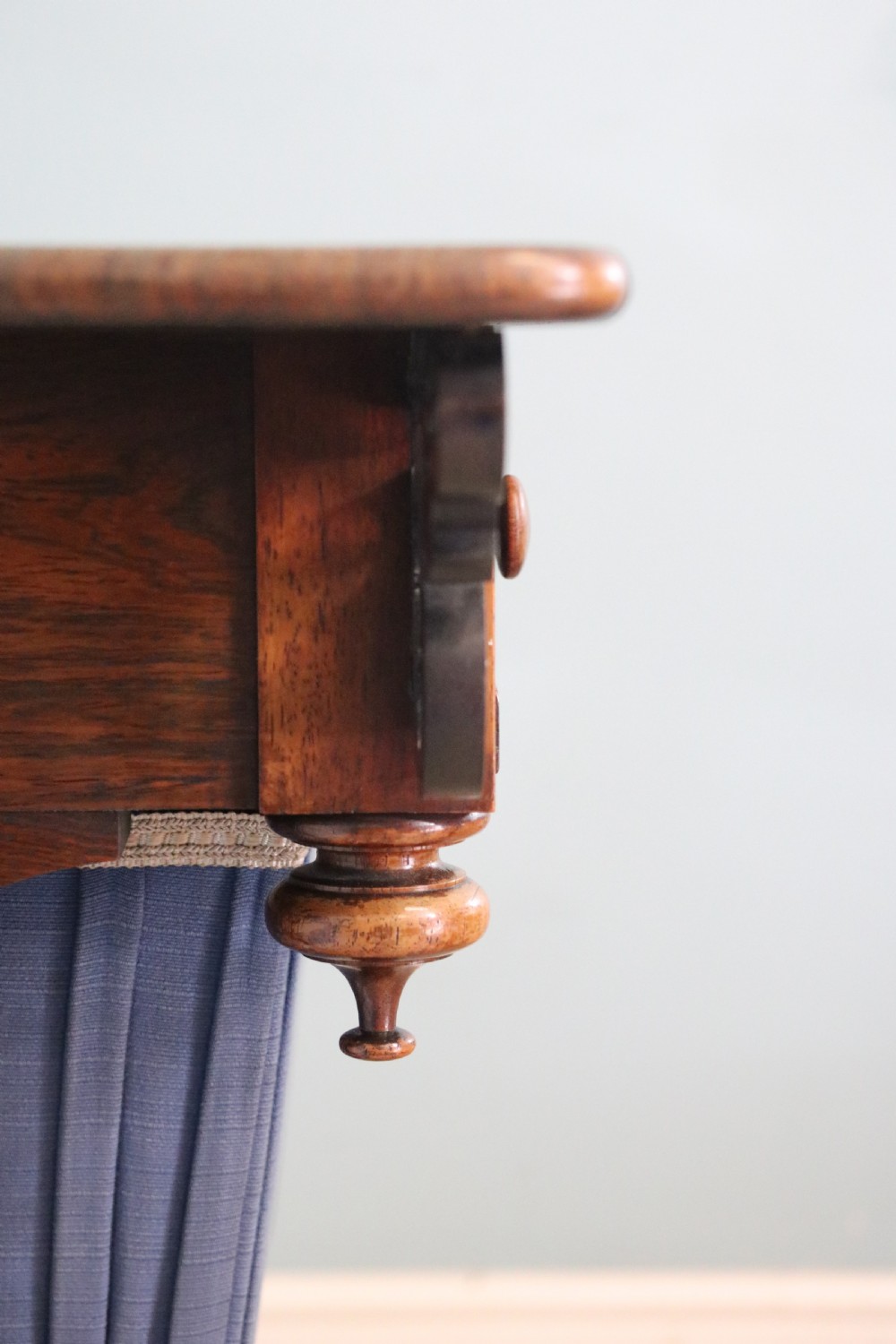 A 19th-century dark rosewood sewing table featuring barley twist legs, side fretwork brackets, a single drawer, and a blue fabric work basket below. View VI