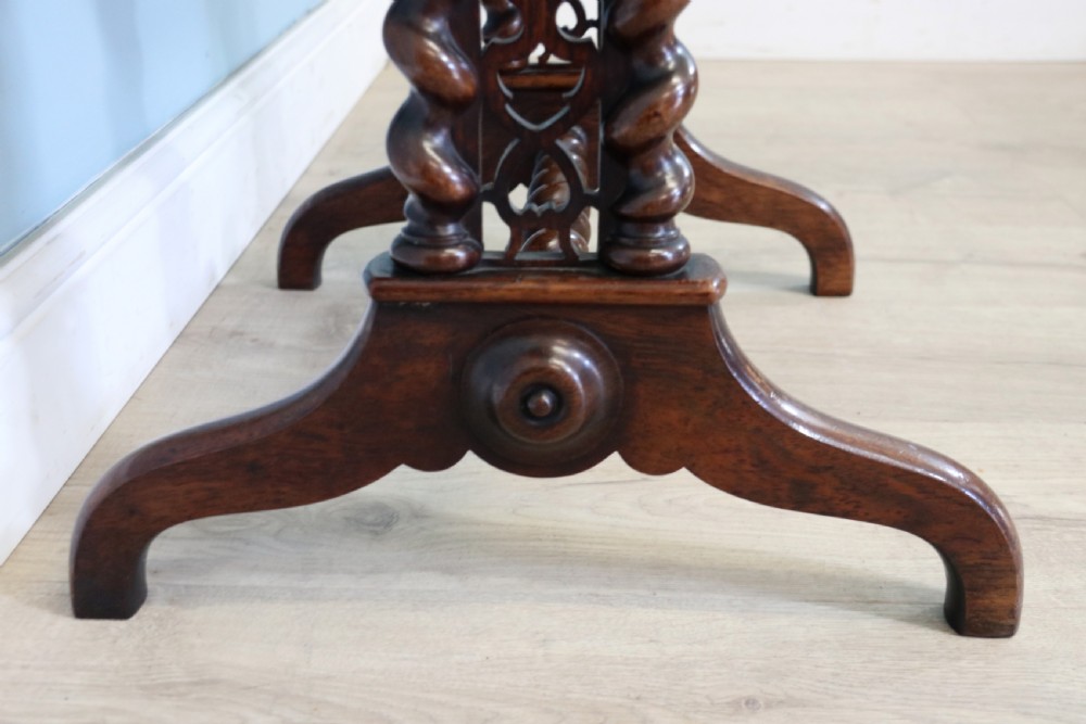 A 19th-century dark rosewood sewing table featuring barley twist legs, side fretwork brackets, a single drawer, and a blue fabric work basket below. View X