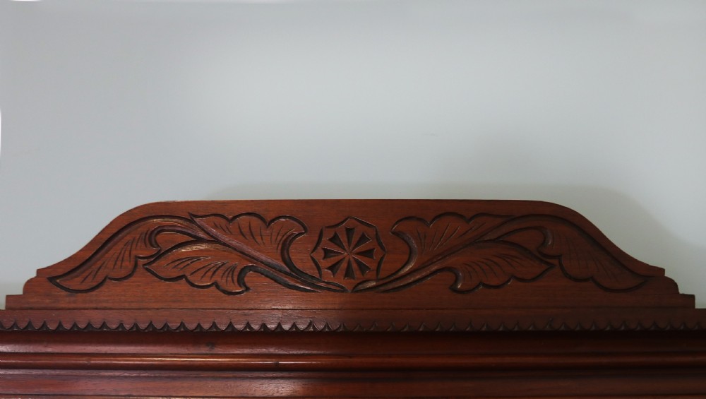 A Victorian American walnut sideboard featuring a mirrored gallery back, carved floral panels, two upper drawers, and two lower cupboard doors. View VII