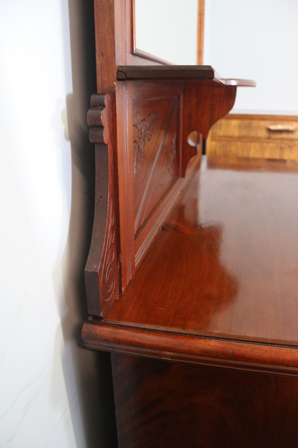 A Victorian American walnut sideboard featuring a mirrored gallery back, carved floral panels, two upper drawers, and two lower cupboard doors. View XII