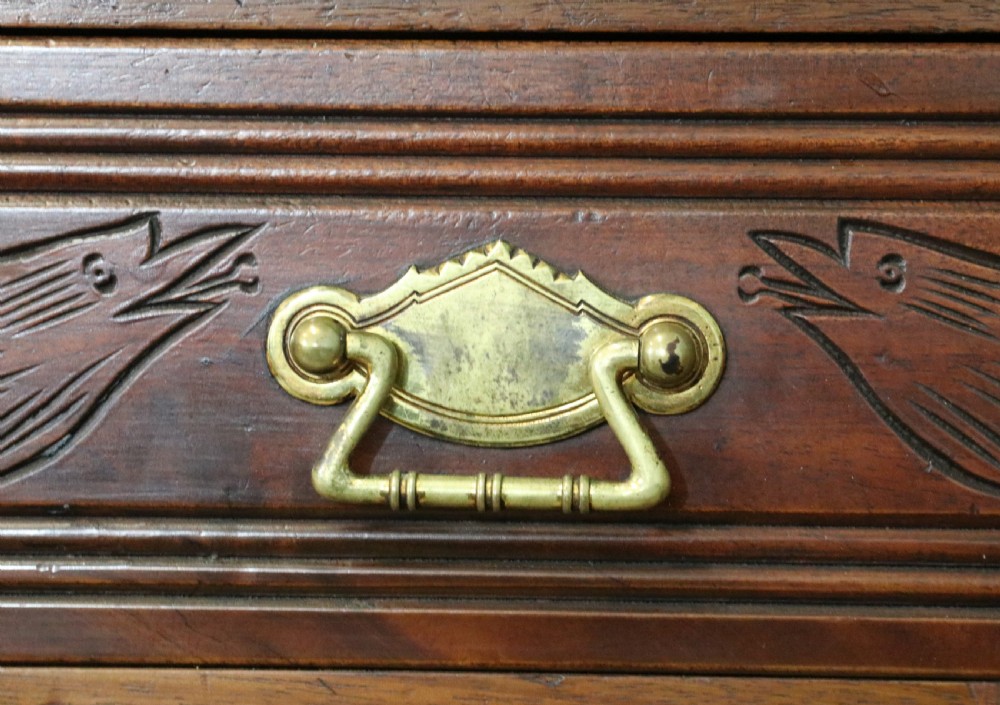 A Victorian American walnut sideboard featuring a mirrored gallery back, carved floral panels, two upper drawers, and two lower cupboard doors. View XVI