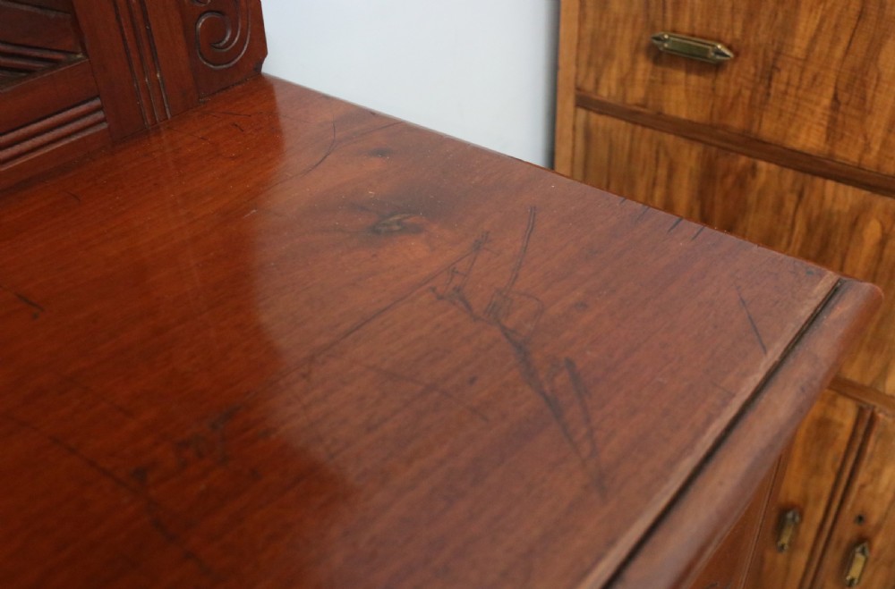 A Victorian American walnut sideboard featuring a mirrored gallery back, carved floral panels, two upper drawers, and two lower cupboard doors. View XXV