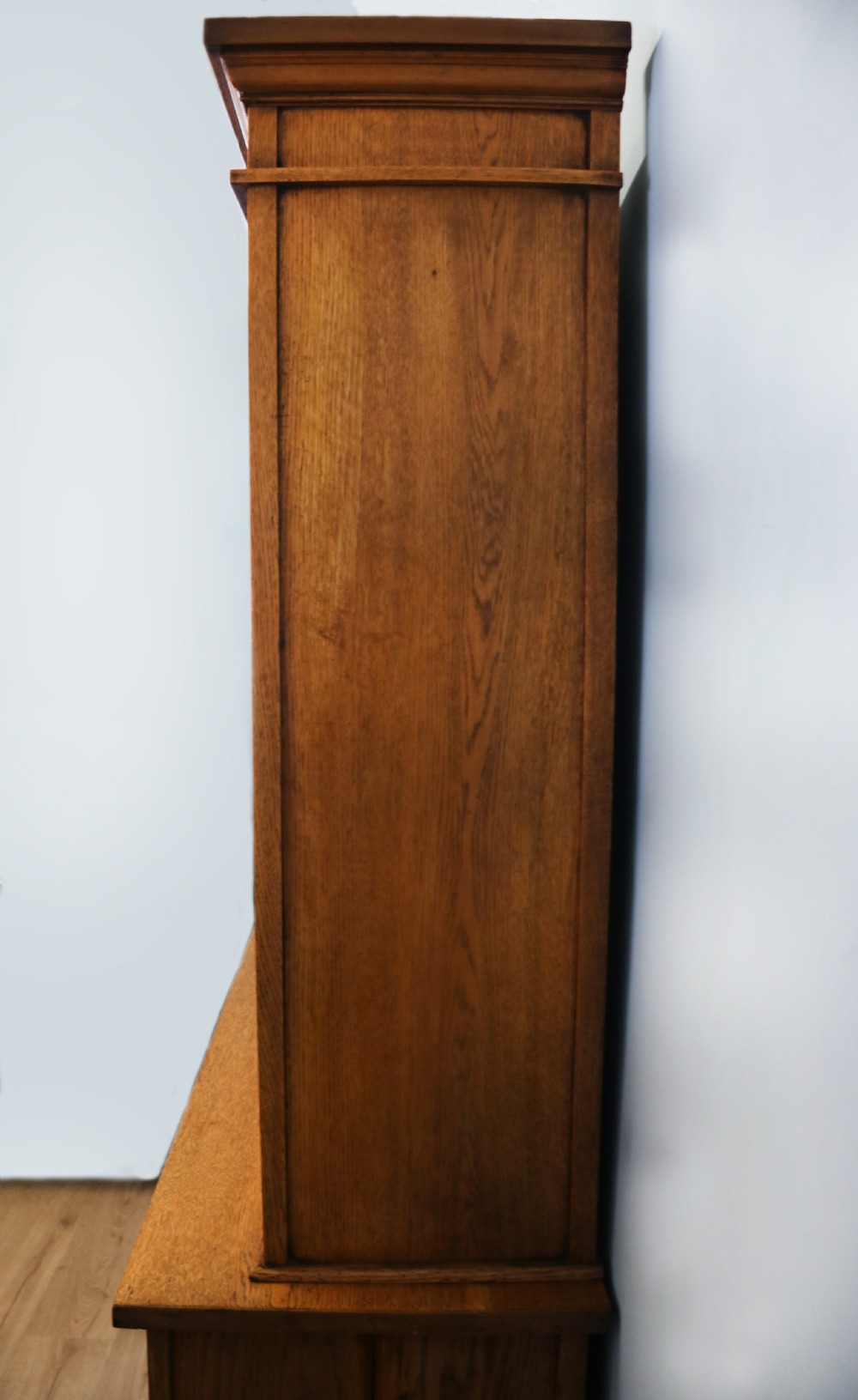 A late nineteenth-century light oak display cabinet featuring glazed upper doors and panelled lower doors decorated with hand-painted white commercial signage. View XXIII