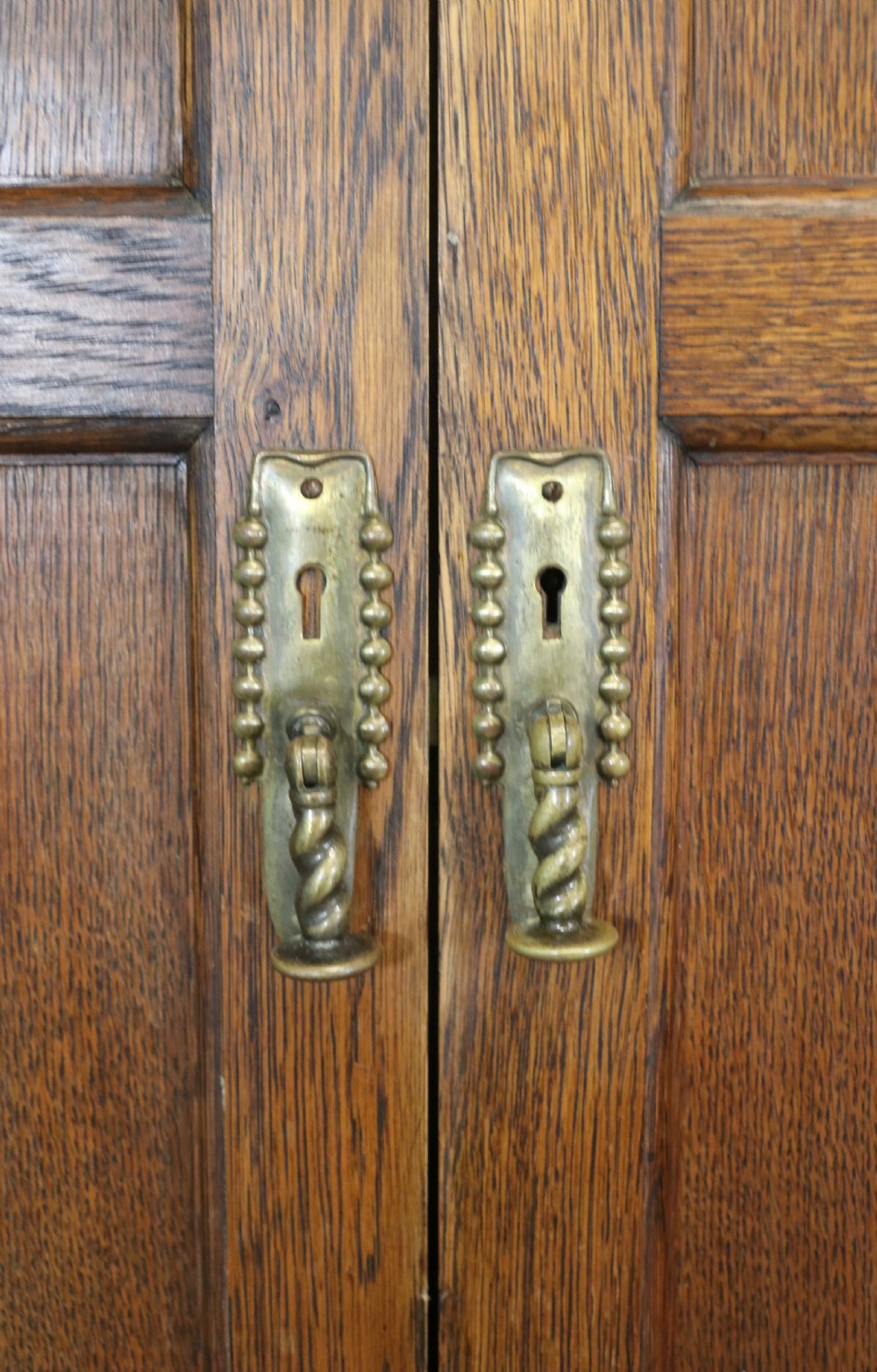 A lovely late 19th or early 20th century oak wardrobe in the ‘campaign’ style. View XIX