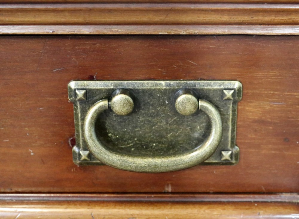 An early 20th-century walnut side cabinet featuring arched leaded glass doors, a top drawer, and two lower drawers with metal handles. View VIII
