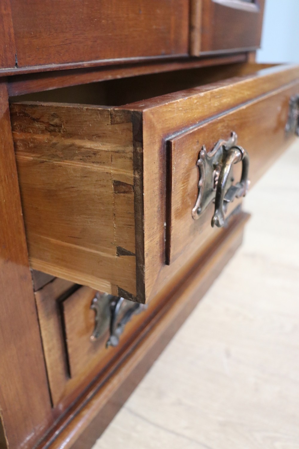 An early 20th-century walnut side cabinet featuring arched leaded glass doors, a top drawer, and two lower drawers with metal handles. View XIII