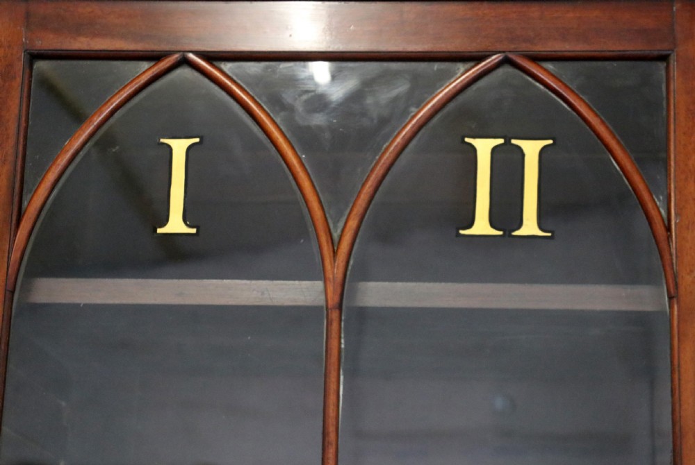 A late Georgian mahogany secretaire bookcase with glazed upper doors featuring Roman numerals, a drop-front fitted writing desk, and two cabinet doors below. View VI