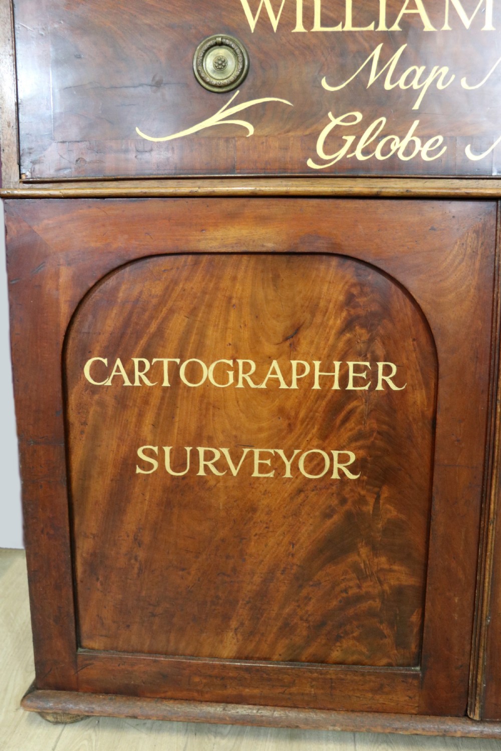 A late Georgian mahogany secretaire bookcase with glazed upper doors featuring Roman numerals, a drop-front fitted writing desk, and two cabinet doors below. View XII