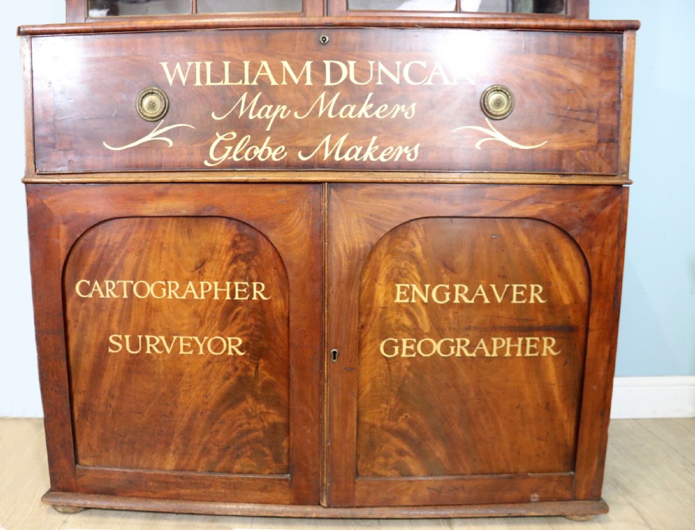 A late Georgian mahogany secretaire bookcase with glazed upper doors featuring Roman numerals, a drop-front fitted writing desk, and two cabinet doors below. View XX