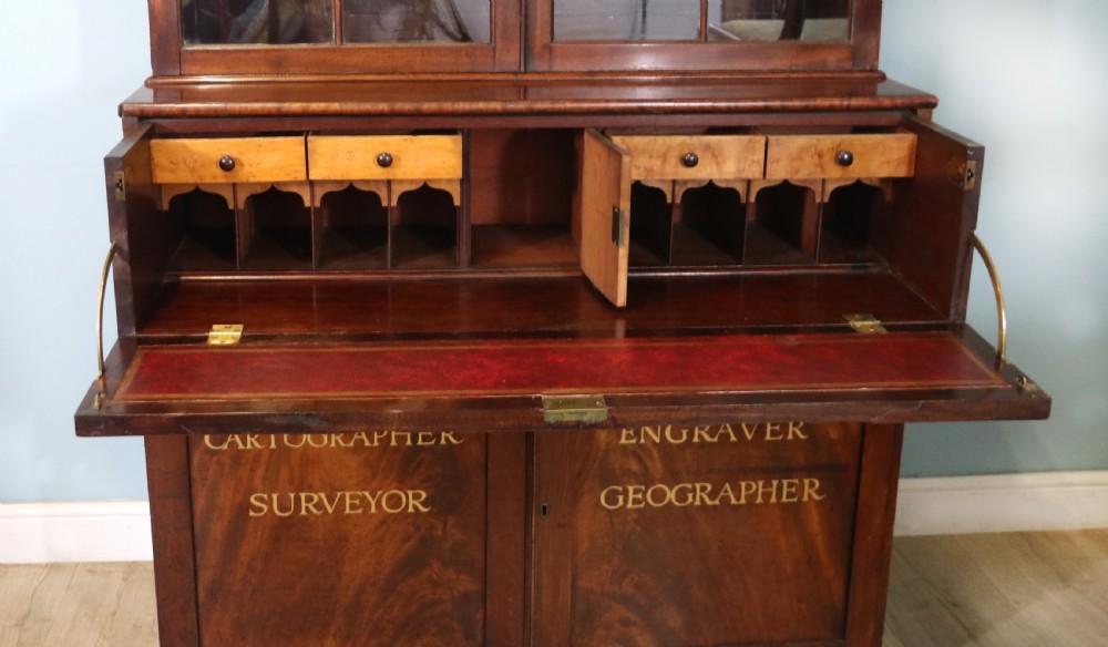 A late Georgian mahogany secretaire bookcase with glazed upper doors featuring Roman numerals, a drop-front fitted writing desk, and two cabinet doors below. View XXIII