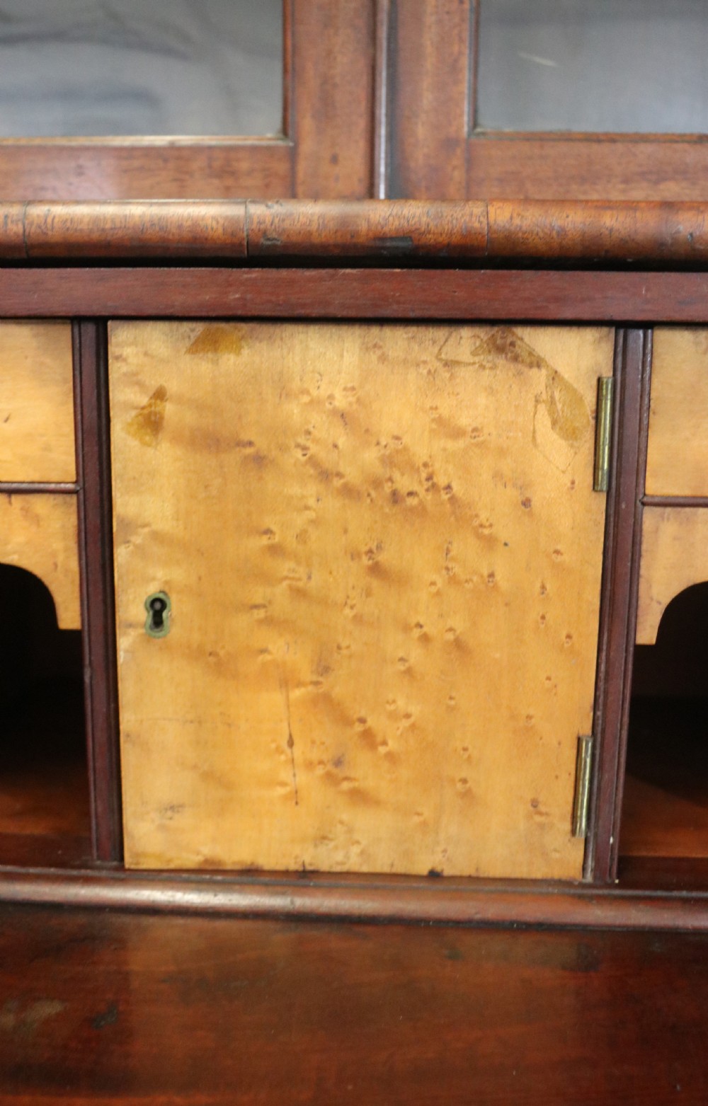 A late Georgian mahogany secretaire bookcase with glazed upper doors featuring Roman numerals, a drop-front fitted writing desk, and two cabinet doors below. View XXIV