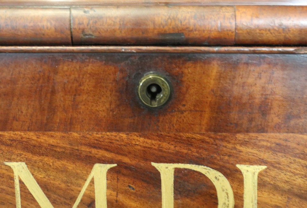 A late Georgian mahogany secretaire bookcase with glazed upper doors featuring Roman numerals, a drop-front fitted writing desk, and two cabinet doors below. View XXVIII