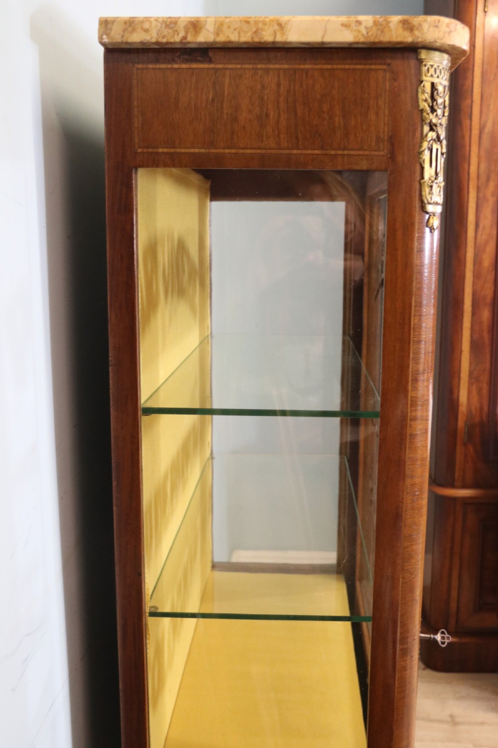 A French mahogany vitrine featuring a marble top, glass display door with gilt perfumery lettering, glass shelves, and brass mounts. View VIII