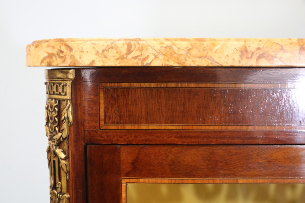 A French mahogany vitrine featuring a marble top, glass display door with gilt perfumery lettering, glass shelves, and brass mounts. View XXII
