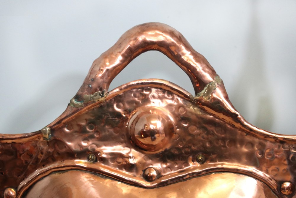 A 19th-century repousse copper panel fire screen featuring a winged warrior profile motif mounted in a wrought-iron frame with splayed feet. View VIII