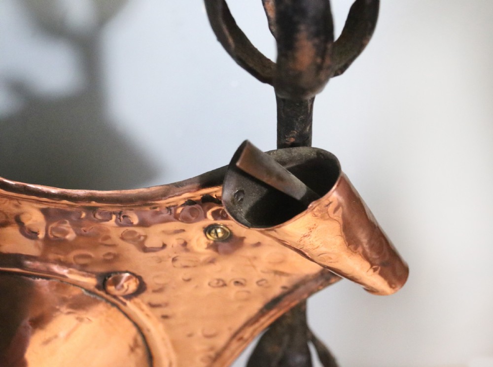 A 19th-century repousse copper panel fire screen featuring a winged warrior profile motif mounted in a wrought-iron frame with splayed feet. View XI