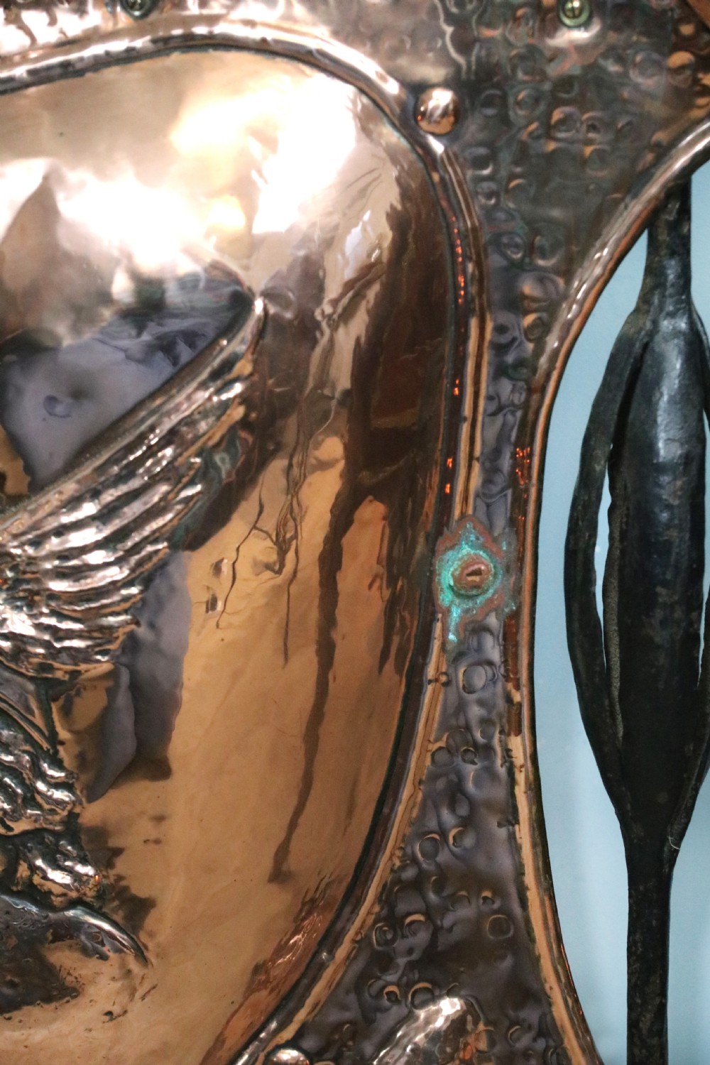 A 19th-century repousse copper panel fire screen featuring a winged warrior profile motif mounted in a wrought-iron frame with splayed feet. View XIII