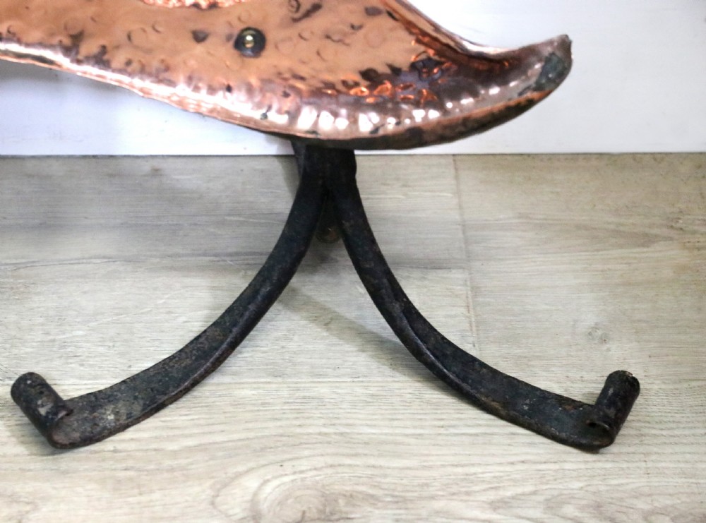 A 19th-century repousse copper panel fire screen featuring a winged warrior profile motif mounted in a wrought-iron frame with splayed feet. View XV