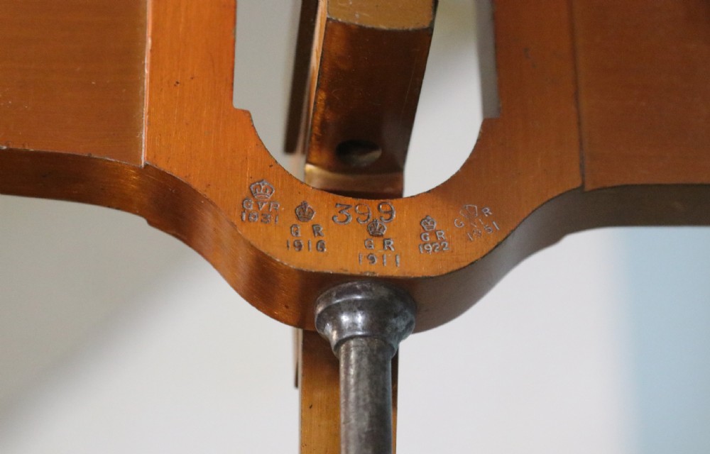 A large hanging brass beam balance scale featuring stamped lettering, suspended chain links, and two circular brass pans. View XI