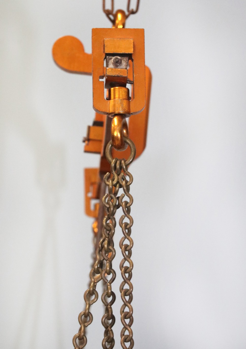 A large hanging brass beam balance scale featuring stamped lettering, suspended chain links, and two circular brass pans. View XXI